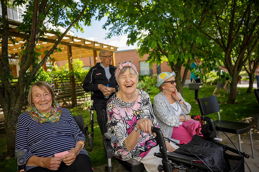 Palvelutalon asukkaat nauravat sisäpihalla